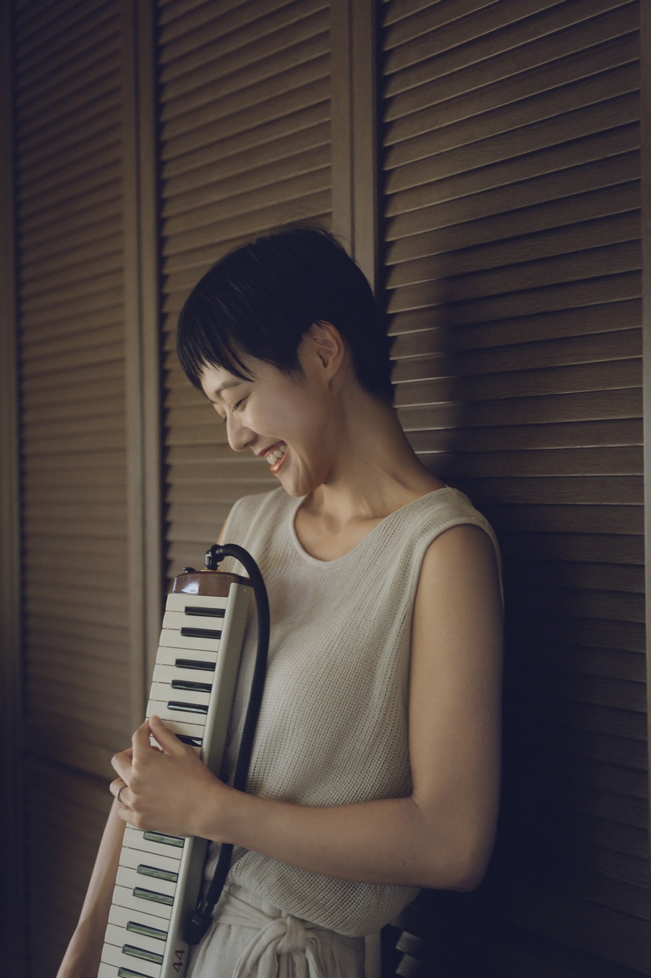 鍵盤ハーモニカを抱えて笑う菅谷詩織